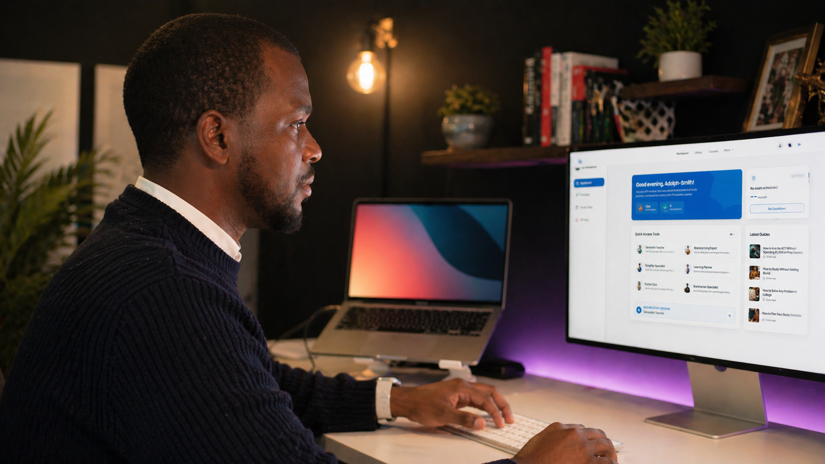 Adolph Smith Gracius working at desk with desktop monitor and laptop, using AI dashboard interface in a home office setup
